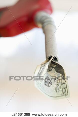Fuel nozzle with dollar bill View Large Photo Image Stock Photo - Fuel nozzle with dollar bill. Fotosearch