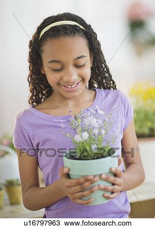 Girl (10-11) holding potted flower View Large Photo Image Stock Image - Girl (10-11) holding potted flower. Fotosearch