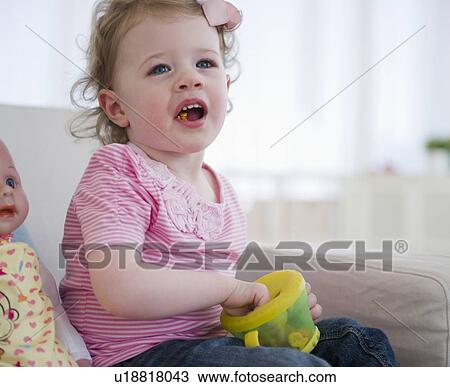 Stock Image - Girl (2-3) eating snacks. Fotosearch