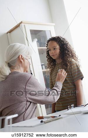 Girl (8-9) at doctor's office View Large Photo Image Stock Image - Girl (8-9) at doctor's office. Fotosearch