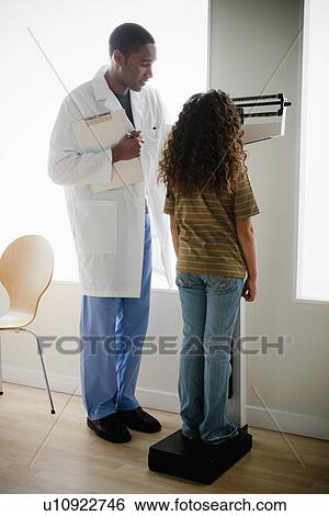 Stock Photograph - Girl (8-9) at doctor's office. Fotosearch
