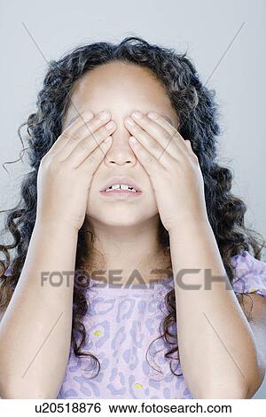 Girl (8-9) covering her eyes, studio shot View Large Photo Image Stock Photograph - Girl (8-9) covering her eyes, studio shot. Fotosearch