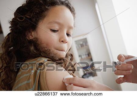 Girl (8-9) having vaccination View Large Photo Image Stock Photo - Girl (8-9) having vaccination. Fotosearch
