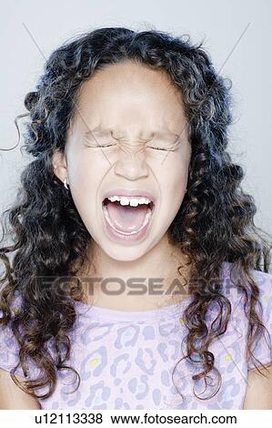 Stock Photo - Girl (8-9) screaming, studio shot. Fotosearch