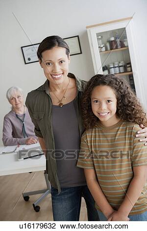 Girl (8-9) with mother at doctor's office View Large Photo Image Stock Image - Girl (8-9) with mother at doctor's office. Fotosearch