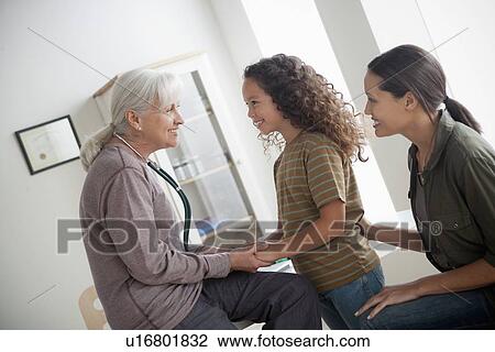 Stock Image - Girl (8-9) with mother at doctor's office. Fotosearch