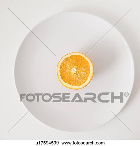 Stock Photo - Half of orange on plate, studio shot. Fotosearch