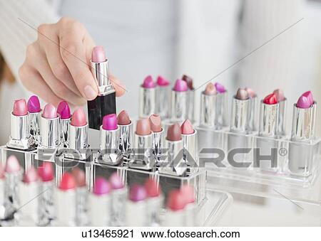 Stock Image - Hand of woman choosing lipstick. Fotosearch