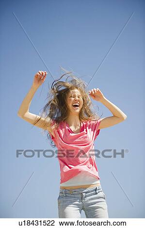 Stock Image - Happy woman jumping outdoors. Fotosearch