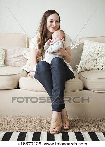 Stock Photography - Happy young mother holding baby boy (2-5 months). Fotosearch