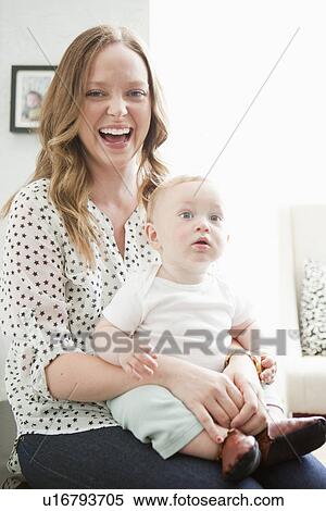 Stock Photography - Happy young mother holding baby girl (6-11 months). Fotosearch