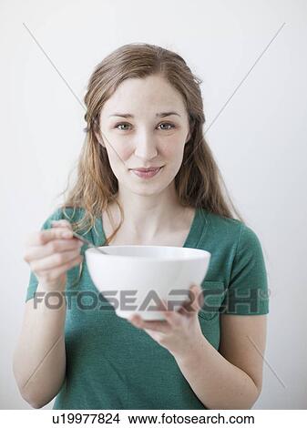 Happy young woman enjoying bowl of cornflakes View Large Photo Image Picture - Happy young woman enjoying bowl of cornflakes. Fotosearch