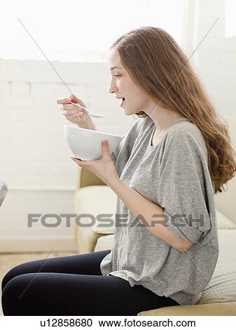 Happy young woman enjoying bowl of cornflakes View Large Photo Image Stock Image - Happy young woman enjoying bowl of cornflakes. Fotosearch