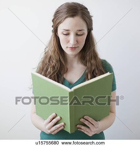 Stock Image - Happy young woman holding green book. Fotosearch