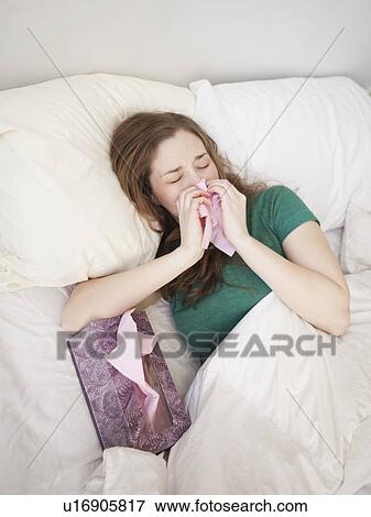 Stock Photo - Ill young woman staying in bed. Fotosearch