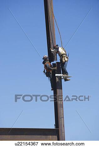 Stock Photo - Male workers on construction site. Fotosearch