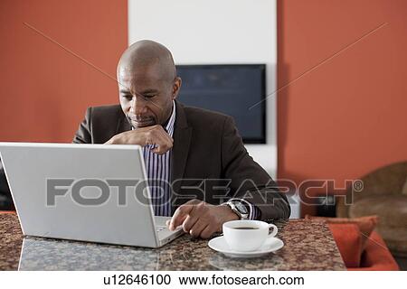 Man enjoying coffee while using laptop View Large Photo Image Stock Image - Man enjoying coffee while using laptop. Fotosearch