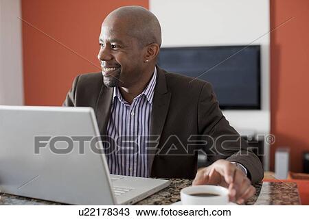 Man enjoying coffee while using laptop View Large Photo Image Stock Image - Man enjoying coffee while using laptop. Fotosearch