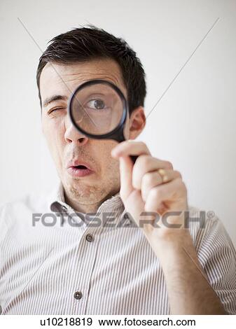 Man looking through magnifying glass View Large Photo Image Stock Photo - Man looking through magnifying glass. Fotosearch