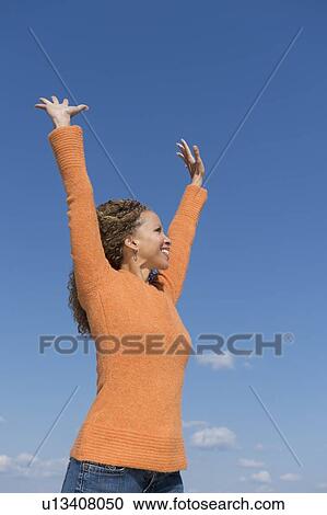 Mature woman with arms raised towards blue sky View Large Photo Image Stock Image - Mature woman with arms raised towards blue sky. Fotosearch