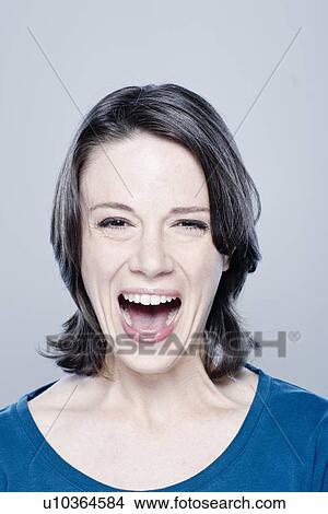Picture - Mid adult woman laughing, studio shot. Fotosearch