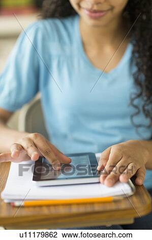 Stock Image - Midsection of girl (12-13) using tablet pc. Fotosearch