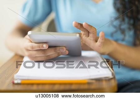 Stock Photo - Midsection of girl (12-13) using tablet pc. Fotosearch