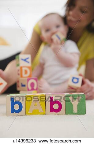 Stock Image - Mother and baby daughter (6-11 months) playing with blocks. Fotosearch
