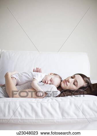 Stock Image - Mother and baby girl (2-5 months) sleeping together. Fotosearch