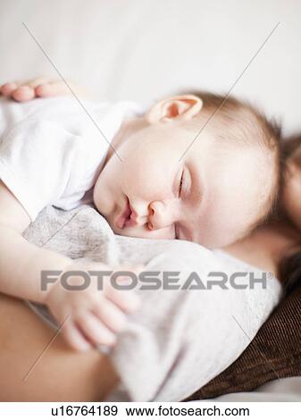 Stock Photo - Mother and baby girl (2-5 months) sleeping together. Fotosearch