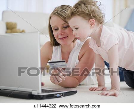 Stock Image - Mother and daughter (2-30 online shopping. Fotosearch
