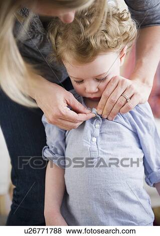 Mother buttoning daughter's (2-3) shirt View Large Photo Image Stock Photo - Mother buttoning daughter's (2-3) shirt. Fotosearch