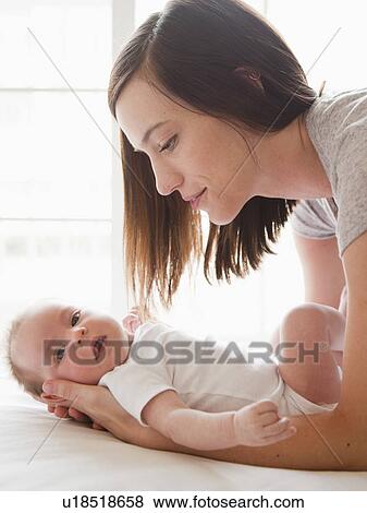 Stock Photo - Mother changing baby girl (2-5 months). Fotosearch
