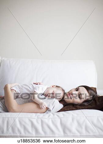 Mother embracing sleeping baby girl (2-5 months) View Large Photo Image Stock Photograph - Mother embracing sleeping baby girl (2-5 months) . Fotosearch