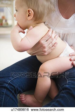 Stock Photograph - Mother holding son (6-11 months) . Fotosearch