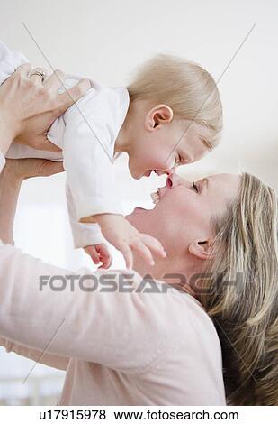 Mother lifting son (6-11 months) View Large Photo Image Stock Photo - Mother lifting son (6-11 months). Fotosearch