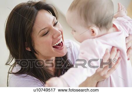 Mother playing with baby daughter (6-11 months) View Large Photo Image Stock Photo - Mother playing with baby daughter (6-11 months). Fotosearch