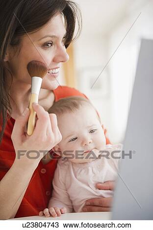 Mother with baby daughter (6-11 months) doing make up View Large Photo Image Stock Image - Mother with baby daughter (6-11 months) doing make up. Fotosearch