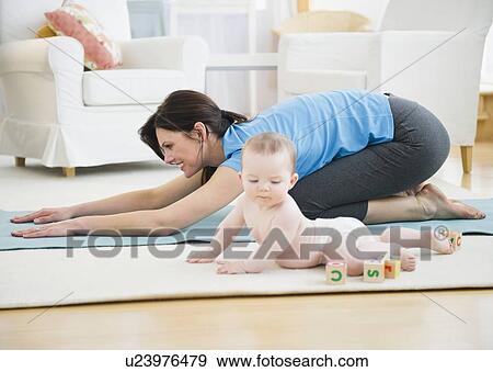 Mother with baby daughter (6-11 months) practicing yoga View Large Photo Image Stock Photo - Mother with baby daughter (6-11 months) practicing yoga. Fotosearch