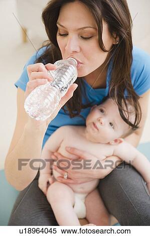 Mother with baby daughter (6-11 months) drinking water View Large Photo Image Stock Photography - Mother with baby daughter (6-11 months) drinking water. Fotosearch