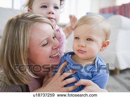 Mother with children (2-3, 6-11 months) at home View Large Photo Image Stock Photo - Mother with children (2-3, 6-11 months) at home. Fotosearch