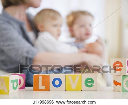 Mother with children (2-3, 6-11 months) at home View Large Photo Image Stock Photograph - Mother with children (2-3, 6-11 months) at home. Fotosearch