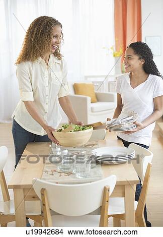 Mother with daughter (10-11) setting table View Large Photo Image Picture - Mother with daughter (10-11) setting table. Fotosearch
