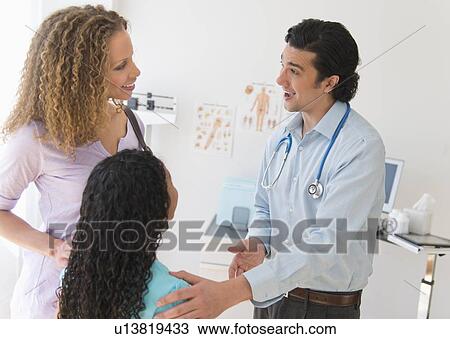 Stock Image - Mother with daughter (12-13) visiting pediatrician. Fotosearch