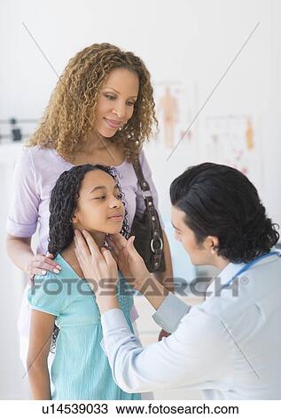 Stock Image - Mother with daughter (12-13) visiting pediatrician. Fotosearch