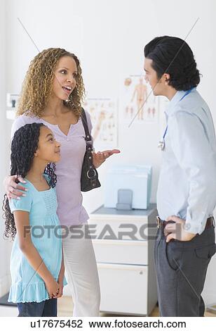 Stock Image - Mother with daughter (12-13) visiting pediatrician. Fotosearch