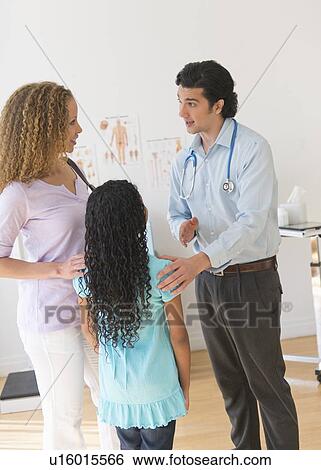 Stock Photograph - Mother with daughter (12-13) visiting pediatrician. Fotosearch