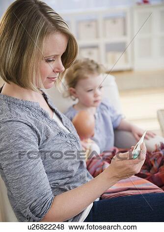 Stock Photo - Mother with sick daughter (2-3) at home. Fotosearch