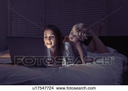 Mother with son using laptop in bed View Large Photo Image Picture - Mother with son using laptop in bed. Fotosearch