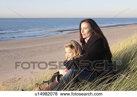 Stock Photo - Netherlands, Zeeland, Haamstede, Mother with daughter on beach. Fotosearch